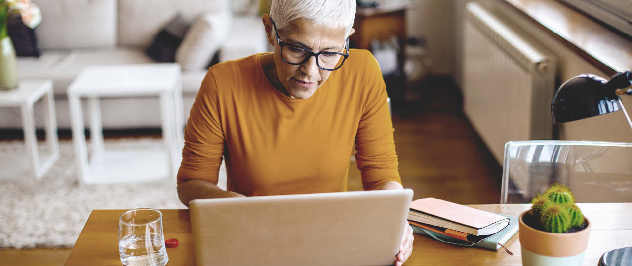 Elderly woman in the living room searches for DBS clinic on the internet with her laptop