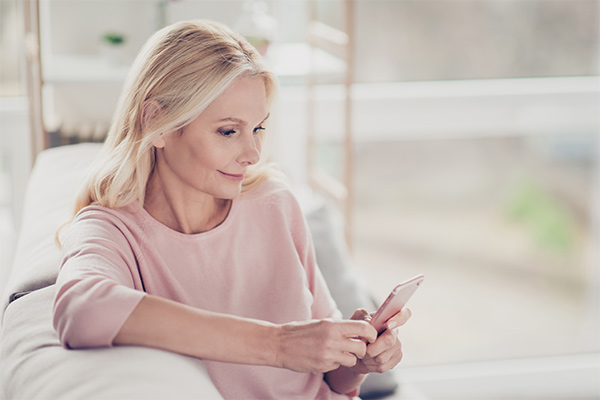 Una mujer mayor mira su teléfono inteligente