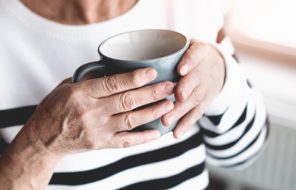 Una mujer mayor sostiene una taza