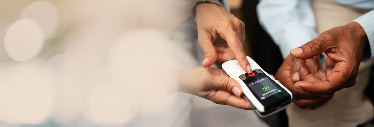 Two people holding a DBS device in their hands